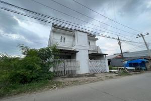 a white building on the side of a street at Hotel O Kost Aisyah Near Citra Grand Galesong City(Pattalassang) in Bilibili +30 photos