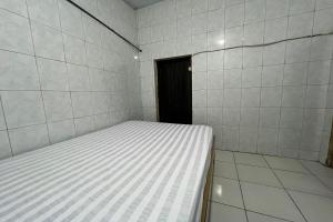 a small room with a bed in it at Hotel O Kost Aisyah Near Citra Grand Galesong City(Pattalassang) in Bilibili