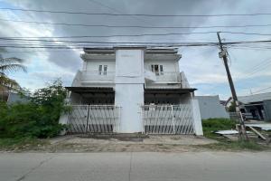 a white house with a white fence in front of it at Hotel O Kost Aisyah Near Citra Grand Galesong City(Pattalassang) in Bilibili