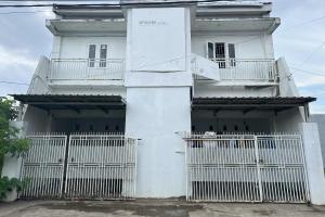 a white house with a white fence in front of it at Hotel O Kost Aisyah Near Citra Grand Galesong City(Pattalassang) in Bilibili +30 photos
