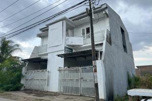 a white building with balconies on the side of it at Hotel O Kost Aisyah Near Citra Grand Galesong City(Pattalassang) in Bilibili