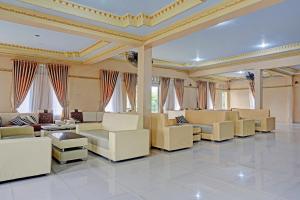 a large living room with white furniture and windows at OYO 91825 Ayu Lestari Homestay in Nganjuk