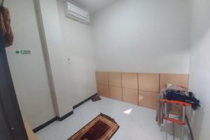 an empty room with a room with a wall at Capital O Guest House Kpri Sejahtera in Purwokerto
