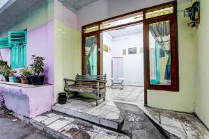 Una habitación vacía con un banco frente a un edificio. en Hotel O Karomah Kostel Syariah, en Semarang 18 fotos más