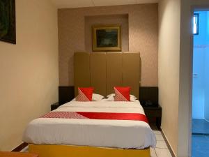 a bedroom with a large bed with red pillows at Hotel O Edotel Smkn 5 Palopo Near Bukit punai in Bua