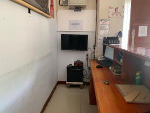 a room with a desk and a computer on a wall at Hotel O Edotel Smkn 5 Palopo Near Bukit punai in Bua +26 photos
