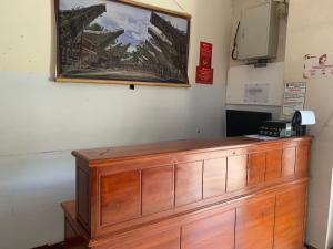 a wooden counter in a room with a picture on the wall at Hotel O Edotel Smkn 5 Palopo Near Bukit punai in Bua