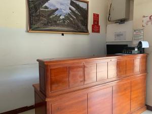 a wooden cabinet in a room with a picture on the wall at Hotel O Edotel Smkn 5 Palopo Near Bukit punai in Bua