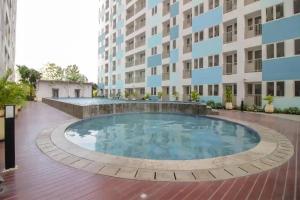 a large swimming pool in front of a building at OYO Life 93139 Apartemen Grand Sentraland By Evi in Jaken 1