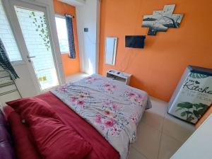 a bed in a room with an orange wall at OYO Life 93139 Apartemen Grand Sentraland By Evi in Jaken 1 +15 photos