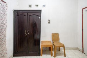 - une porte en bois et 2 chaises dans la chambre dans l'établissement Hotel O Penginapan Tulimario Syariah, à Jambi