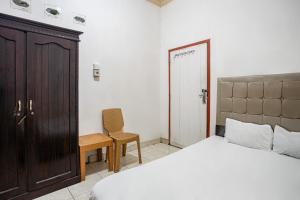 une chambre avec un lit, une table et une chaise dans l'établissement Hotel O Penginapan Tulimario Syariah, à Jambi