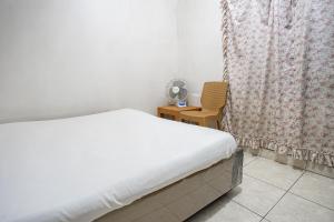 une chambre avec un lit, une chaise et une fenêtre dans l'établissement Hotel O Penginapan Tulimario Syariah, à Jambi 16 autres photos