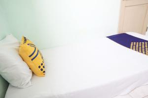 ポノロゴにあるSPOT ON 93611 Kost Pak Suyatno Syariah 2の白いベッド(枕2つ付)
