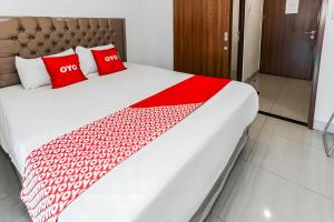 a large bed with two red pillows on it at Fortune 88 Kamala Lagoon Reception at Indomaret and White Forest in Bekasi