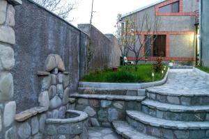a garden with a stone walkway next to a building at HOTEL GUGLUX &WINE CELLAR in Tʼelavi