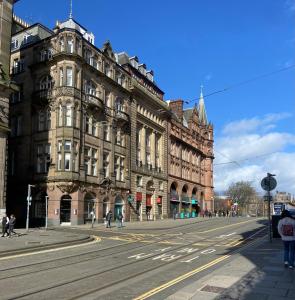 une rue vide devant un grand bâtiment dans l'établissement Haymarket Centro , Flat familiar quarto privativo banheiro compartilhado, à Édimbourg