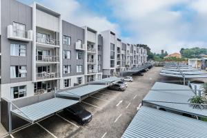 ein Parkplatz mit einer Reihe von Apartmenthäusern in der Unterkunft Modern Comfort Retreat in Central Sandton with WiFi , Gym and Pool in Johannesburg