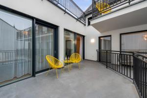 two yellow chairs and a table on a balcony at Modern Housing Apartments in Vienna