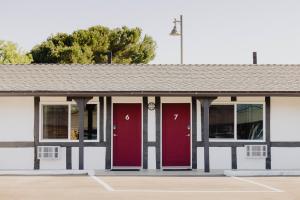 ブエルトンにあるHotel Hyggeの駐車場内の赤い扉のある建物