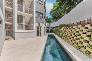 einen externen Blick auf ein Gebäude mit einem Pool in der Unterkunft Modern Comfort Retreat in Central Sandton with WiFi , Gym and Pool in Johannesburg