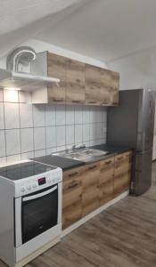 a kitchen with a stove and a sink and a refrigerator at Bajkowe Zacisze - Basen, Ping-pong, Bilard in Mielno