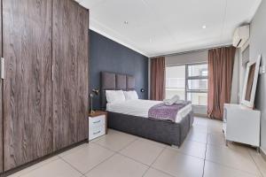 ein Schlafzimmer mit einem Bett und einem Fernseher in der Unterkunft Modern Comfort Retreat in Central Sandton with WiFi , Gym and Pool in Johannesburg + 19 Fotos