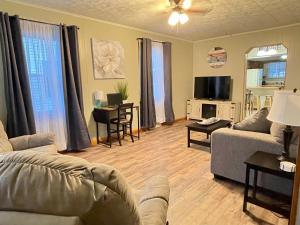 un soggiorno con un divano, un tavolo e una TV di Boomer Bungalow a Boomer