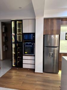 a kitchen with a stainless steel refrigerator and cabinets at Vale's Cottage in Huaraz