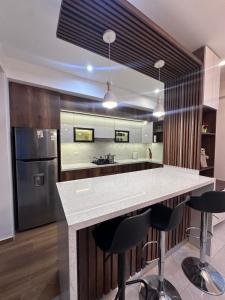 a kitchen with a counter with bar stools at Vale's Cottage in Huaraz