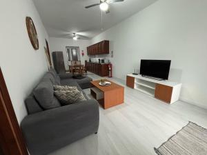 a living room with a couch and a tv at Casa da Praça II in Vila Nova
