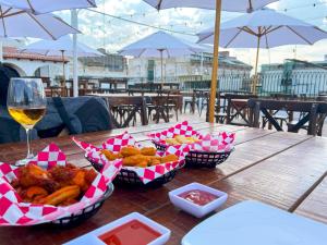 a table with baskets of food and a glass of wine at Hotel Frances in Guadalajara
