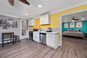 ヒューストンにあるCozy & Spacious 1BR in Montrose Walk to Top Attractionsの黄色と白の壁のキッチン、ベッド1台が備わります。