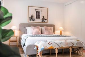 a bedroom with a bed with pillows and a picture on the wall at Hjemme on The Hill in Sunshine Beach