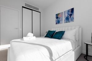 Doncaster EastSpecious 2beds Apt Doncaster east Wifi and carpark的白色卧室配有白色床和蓝色枕头 更多6张照片