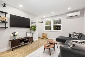 a living room with a couch and a tv on a wall at Modern Ballard Retreat Near Beach & Parks in Seattle +23 photos