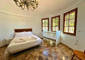 a bedroom with a bed and windows and a chandelier at Villa Maréa Private Luxury Villa in Santa Faz +42 photos
