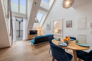 a living room with a wooden table and blue chairs at Hillside Living Vienna in Vienna