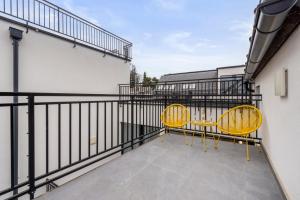 a balcony with two yellow chairs and a railing at Hillside Living Vienna in Vienna