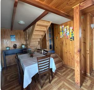 a dining room with a table and chairs and wooden walls at Hostal Livary Puerto Varas in Puerto Varas
