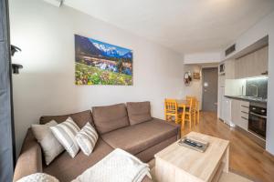 una sala de estar con un sofá y una mesa en Apartamento con Encanto Baqueira 1500, en Naut Aran (Alto Arán) 18 fotos más