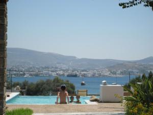 a group of people sitting in a swimming pool at Roses Beach in Parikia