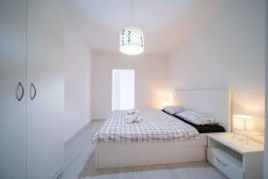 a white bedroom with a bed with a teddy bear on it at Apartments with parking space Palit, Rab - 23622 in Rab
