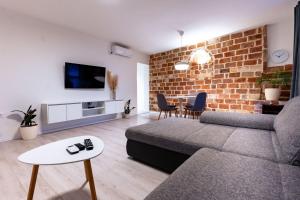 a living room with a couch and a brick wall at Apartments with parking space Palit, Rab - 23622 in Rab