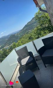 a balcony with two chairs and a glass table at Best Gerês village in São Pedro