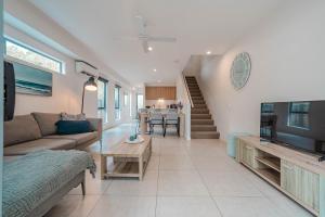 Una sala de estar con un sofá y un televisor. en Suncoast Beach Drive Townhouses, en Yaroomba