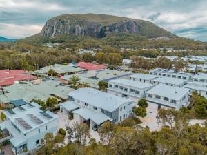 una vista aérea de una ciudad con una montaña en el fondo en Suncoast Beach Drive Townhouses, en Yaroomba