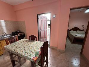 a kitchen and dining room with a table and a bedroom at Centricos Departamentos in Termas de Río Hondo