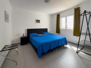 a bedroom with a blue bed and a window at Casa Branca Beach in Santa Maria