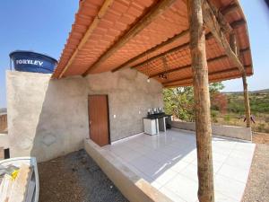 an outdoor kitchen under a wooden pergola at Los Arboles - Quarto com Banheiro in Alexânia